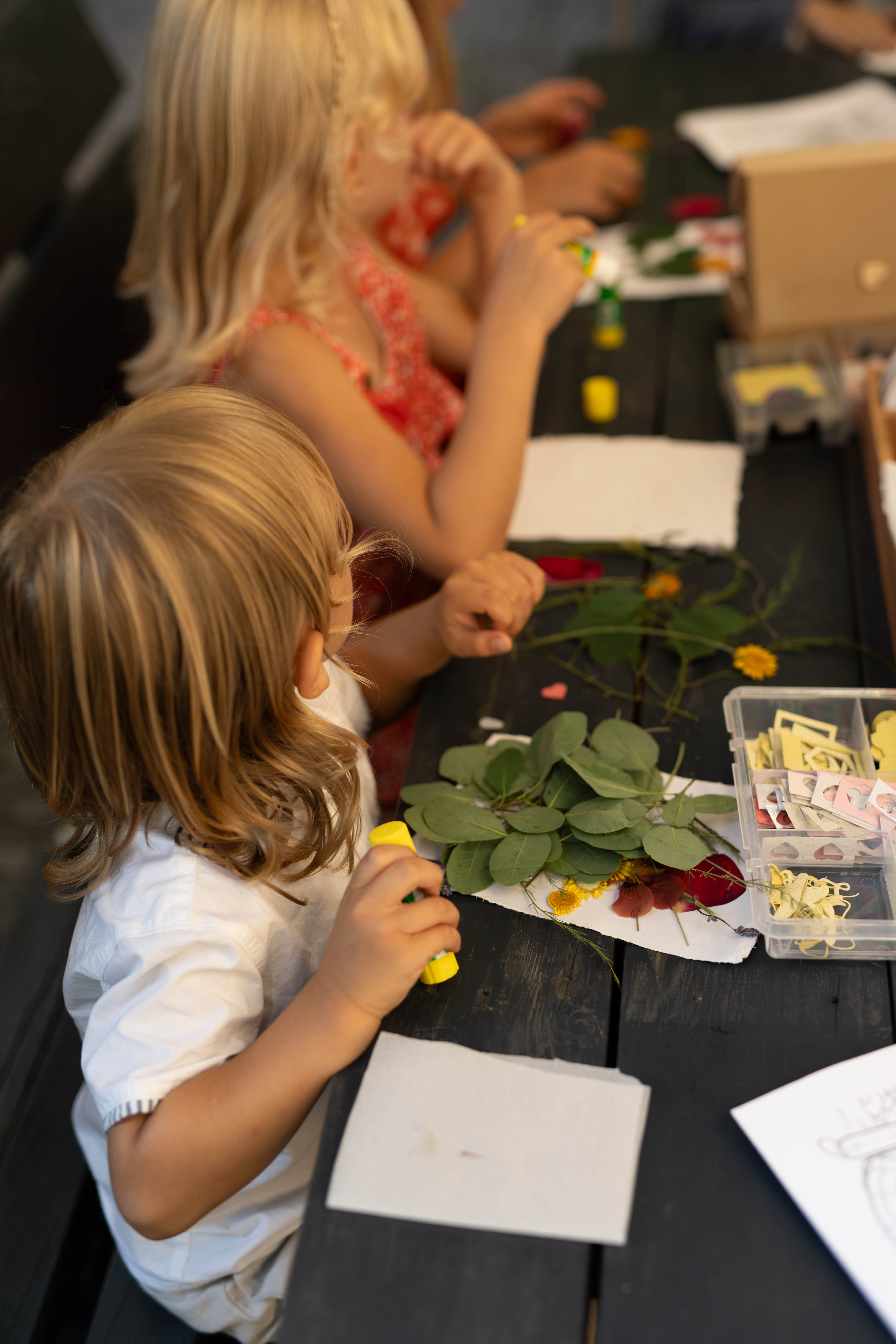 Dzieci tworzące rękodzieło z kwiatami na weselu